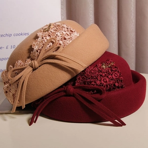 Detail of wool cloche hat showing lace flower embroidery and elegant bow ribbons