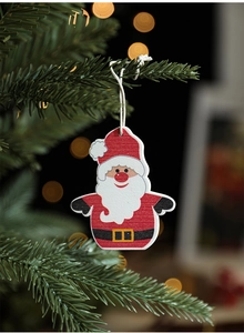Close-up of Santa Claus wooden ornament hanging on a Christmas tree with warm lights