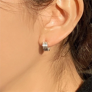 Close-up of triple-layered silver hoop earrings showing polished texture on model
