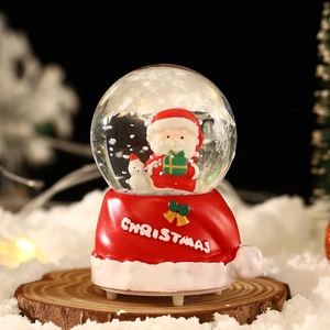 Boule à neige de Noël lumineuse avec Père Noël et bonhomme de neige sur base rouge
