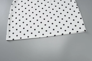 Detail of polka dot print fabric showing high-quality stitching and smooth texture