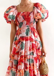 Detail of floral smocked dress featuring puff sleeves and a multi-tiered A-line skirt