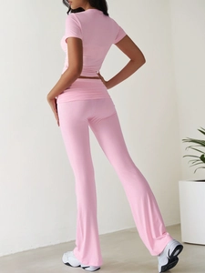 Pink casual two-piece set featuring short sleeve top and flared trousers from a side back view
