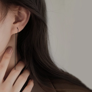 Minimalist long black chain threader earrings worn by model for elegant style