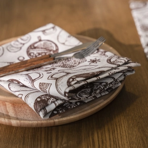 Plaid Christmas napkin with brown hand-drawn kitchen patterns on a wooden plate