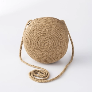 Vue détaillée d'un sac à bandoulière rond en paille tressée marron clair pour enfants