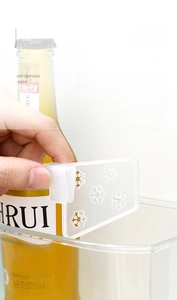 Detail of adjustable clip-on refrigerator door organizer divider with snowflake pattern