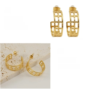 Détail des boucles d'oreilles en grille plaquées or 18K avec une finition en acier poli