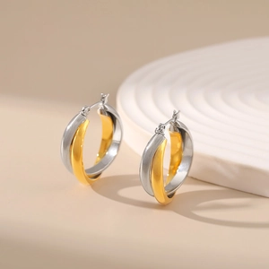 Two-tone intertwined hoop earrings in gold and silver finish with minimalist crossed design