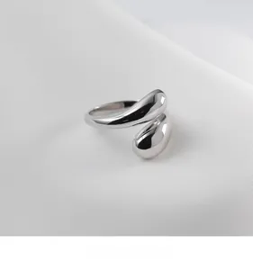 Macro shot of liquid metal style open ring with polished silver finish and teardrop design