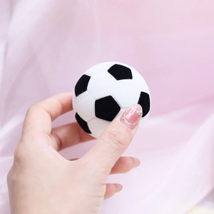 Creative soccer ball shaped velvet jewelry ring box held in hand with pink background