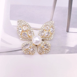 Vue détaillée d'une broche papillon avec perle centrale et ailes serties de zircons