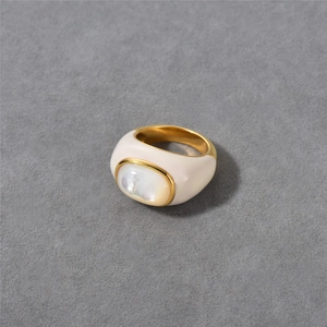Detail shot of vintage 18k gold plated ring with white enamel and oval mother of pearl stone