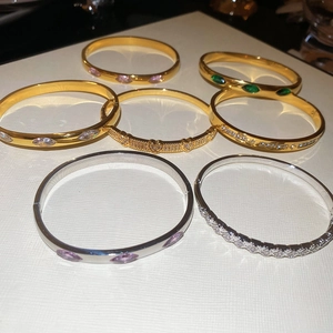 Detailed top view of gold and silver bracelets featuring oval and heart cubic zirconia