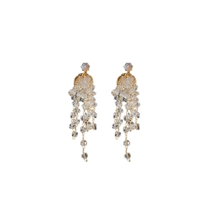 Boucles d'oreilles pampilles dorées avec design méduse et perles en cristal sur fond blanc
