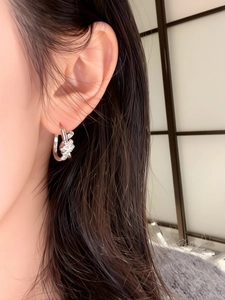 Close-up of silver knot earrings with sparkling cubic zirconia on a model for display