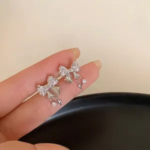 Boucles d'oreilles nœud argenté avec pampilles en zircon et breloques étoile évidée