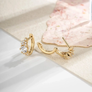 French vintage gold hoop earrings with sparkling zircon stars on textured paper background