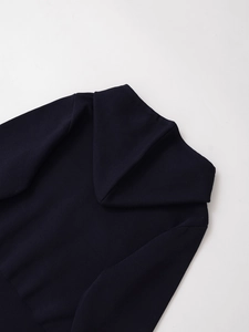 Detail of navy blue knitted sweater showing high-quality rib-knit cuffs and large lapel collar
