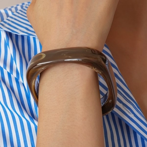 Close-up of amber resin square bangle with natural marbled texture on wrist