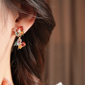 Close-up of a model wearing colorful zircon butterfly earrings with gold plating