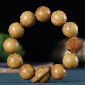 Gros plan de perles bouddhistes de 20 mm avec grain de bois naturel et motif gravé