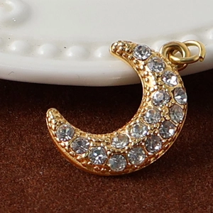 Macro view of 24K gold plated moon pendant featuring sparkling cubic zirconia crystals