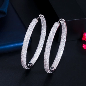 Macro side view of silver hoop earrings with pave set zircon on a dark display
