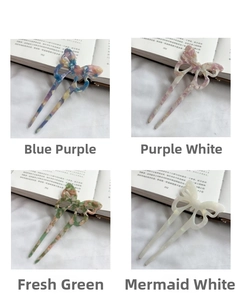 Close-up of butterfly acetate hair sticks with marble texture and double-prong U-shape design