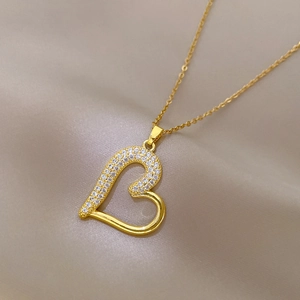 Close-up of gold heart necklace featuring a half-pavé rhinestone and half-polished finish