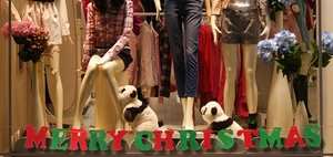 Detailed close-up of Merry Christmas felt banners hanging in a seasonal apparel store