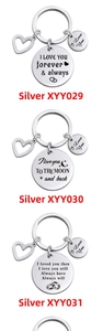Detail of silver stainless steel keychains with round pendants and heart charms for couples