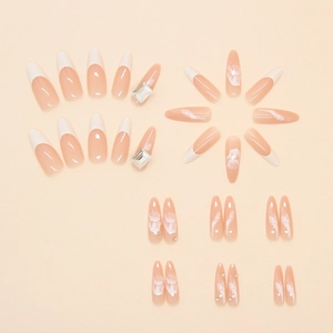 Macro shot of long almond press-on nails with French tips, marble patterns and rhinestones