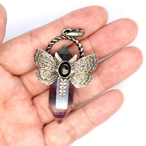 Silver dragonfly pendant with hexagonal fluorite crystal shown in hand