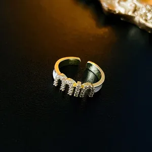 Macro shot of gold-plated MIU letter ring with sparkling pavé cubic zirconia