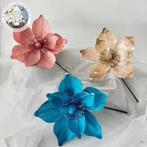Detail of layered velvet Christmas butterfly flowers in teal and pink for festive decor