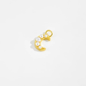 Close-up of a golden moon pendant featuring white pearl embellishments and a ring hook
