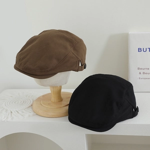 Détail de bérets pour enfants en marron et noir avec boucles de réglage en métal