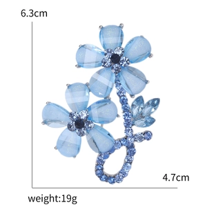 Elegant blue crystal flower brooch with rhinestones and alloy leaves on white background