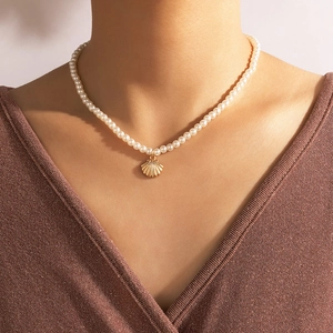 Elegant single-layer pearl necklace featuring a golden seashell pendant on neck