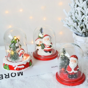 Lighted Christmas glass dome with Santa and snowman figurines on a snowy base