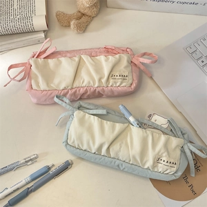 Detail of blue and pink bow stationery pouches with side ribbons and fabric labels