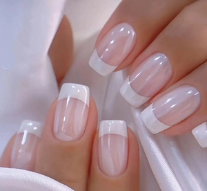 Close-up of elegant French tip press-on nails in pink base and white square shape