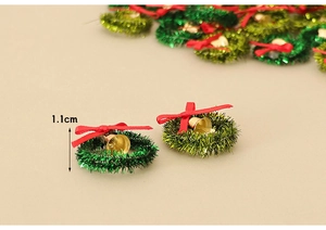 Macro shot of miniature 1.1cm Christmas wreath with red bow and gold bell detail