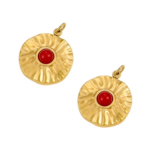 Detailed view of golden textured round charms with red center beads and wavy finish
