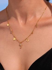 Detail of 18k gold plated ball chain necklace with dolphin, heart, and clover charms