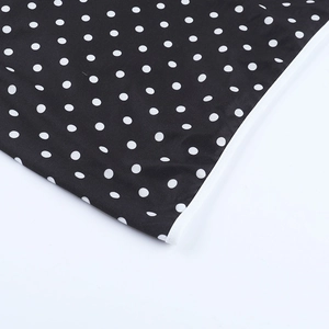 Détail du tissu à pois avec coutures blanches sur une robe courte noire
