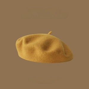 Detail of premium mustard yellow wool beret featuring 2023AW minimalist branding
