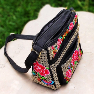 Ethnic style embroidered shoulder bag with floral patterns on black canvas and multi-zippers