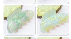 Close-up of pearlized heart hair claw clip with iridescent green and yellow highlights